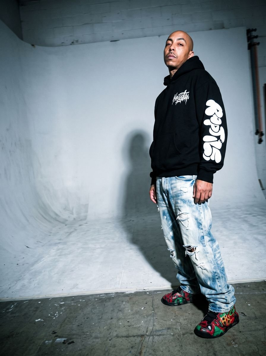 Black zip-up hoodie styled in a studio editorial
