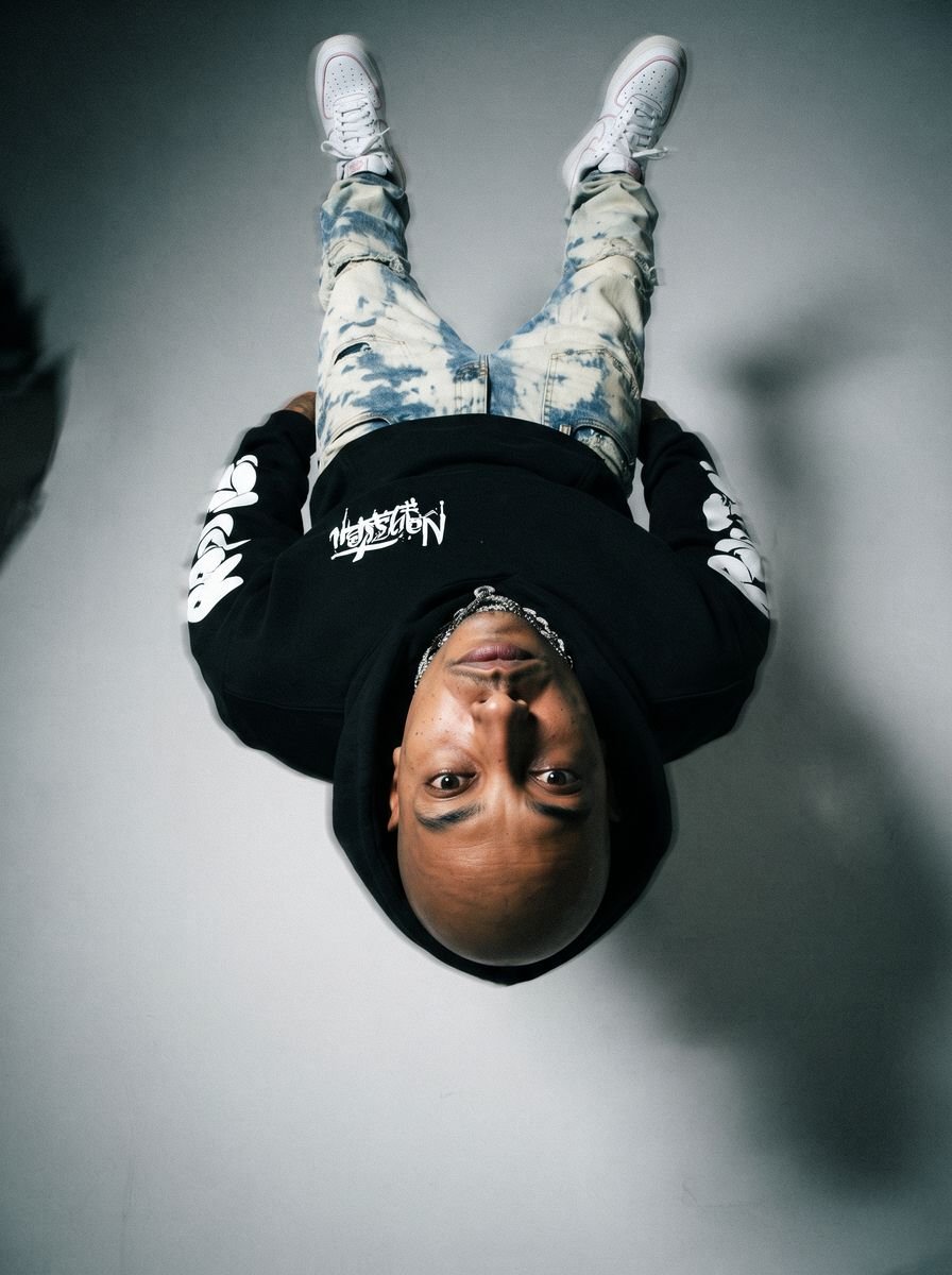 Black zip-up hoodie styled in a studio editorial