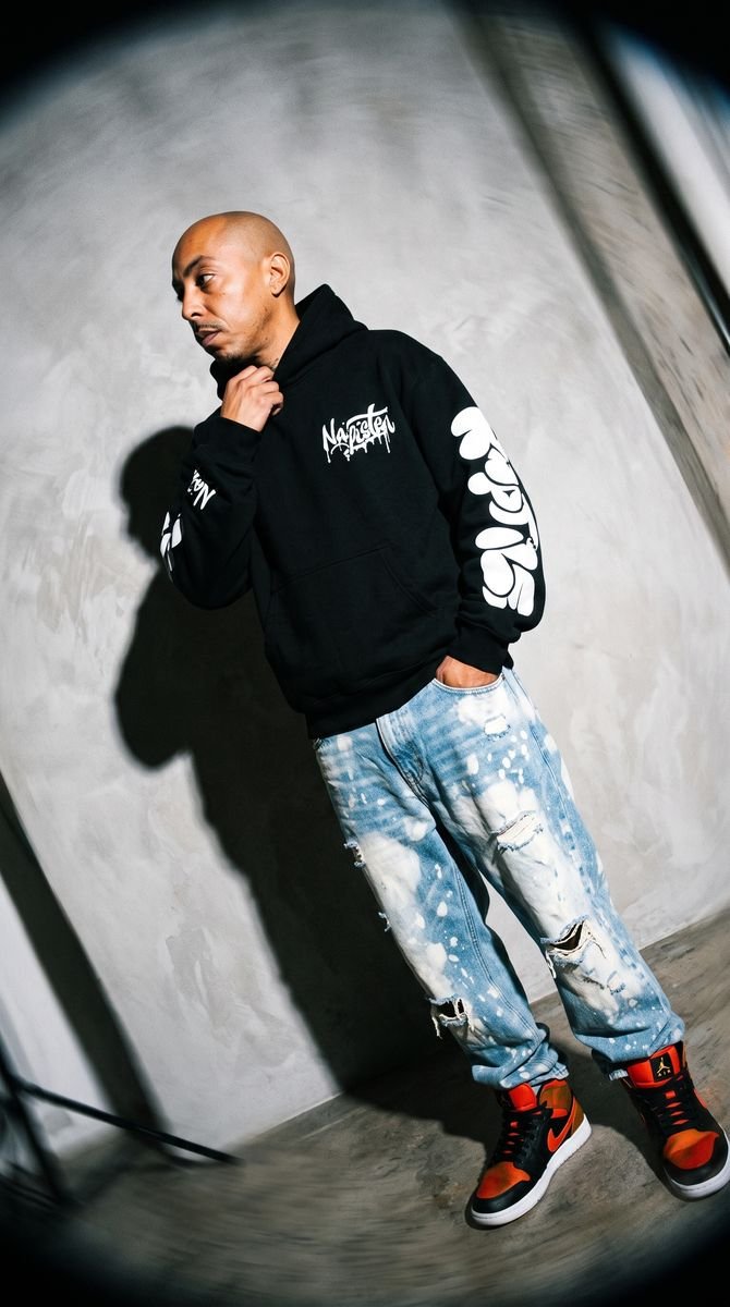Black zip-up hoodie styled in a studio editorial