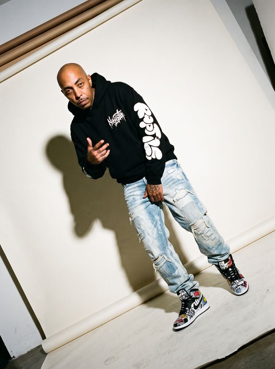Man in a black graphic hoodie with red and white high-top sneakers